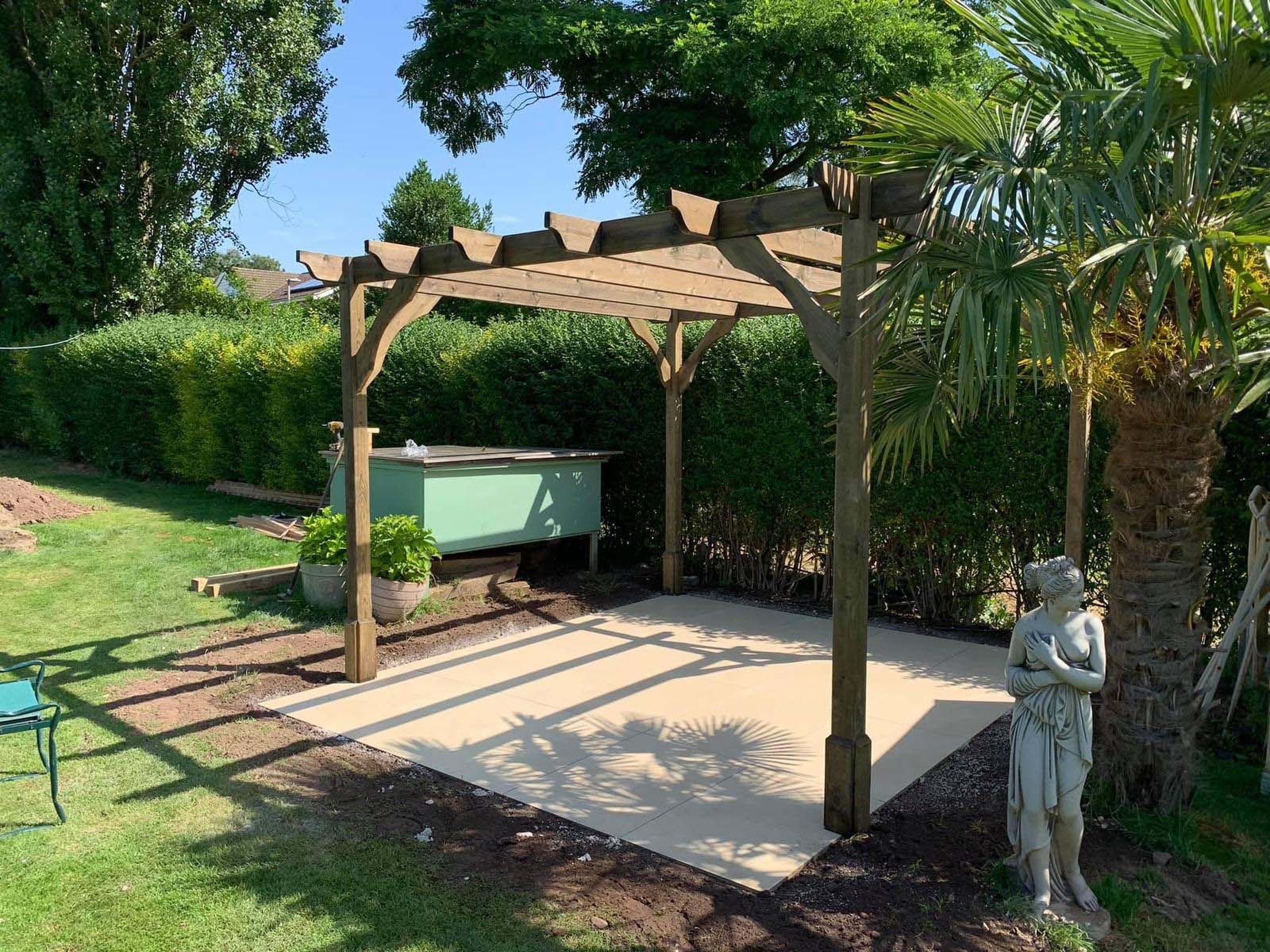 Wooden pergola with concrete base in UK back garden