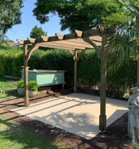 Wooden pergola with concrete base in UK back garden